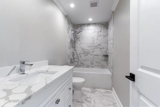 White marble tile bathroom with tub surround, vanity, and hexagon floor