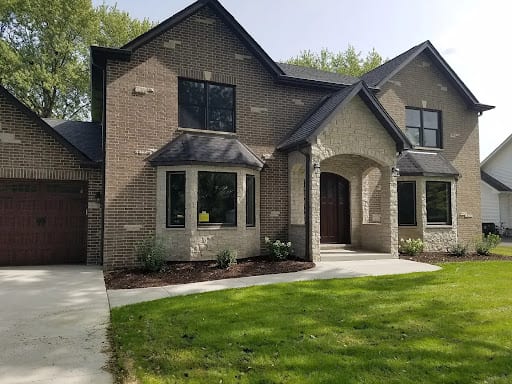 Two-story brick home with stone accents and arched entryway