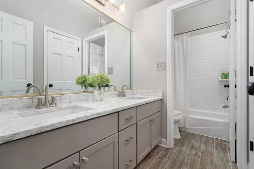 Double sink gray vanity with marble countertop and tub shower combo