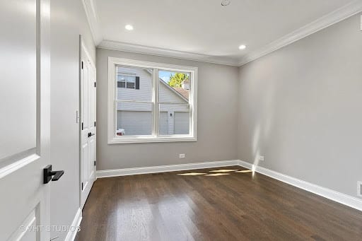 Empty room with dark hardwood floors, gray walls, and white trim