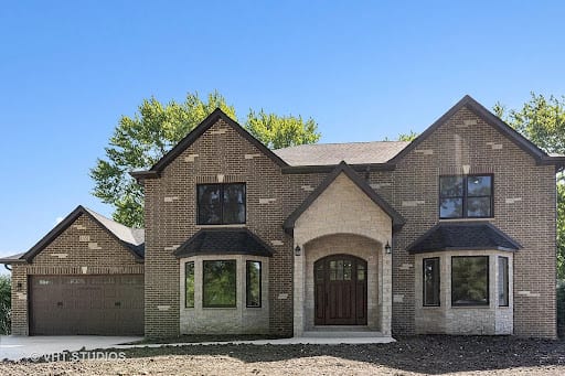 Newly built two-story brick home with arched entryway and attached garage