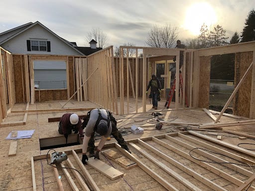 Workers framing wooden walls during a home addition construction project