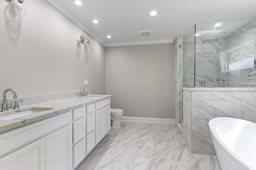 Luxury bathroom with marble floors, white vanity, and freestanding tub