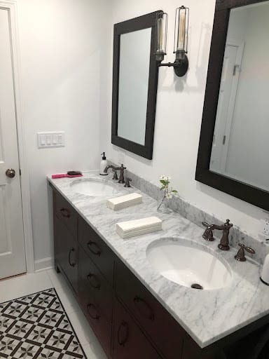 Double sink bathroom vanity with marble countertop and dark wood cabinets