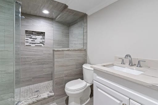 Modern walk-in tile shower with glass door and white vanity
