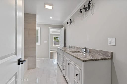 Double sink bathroom vanity with granite countertop and white cabinetry